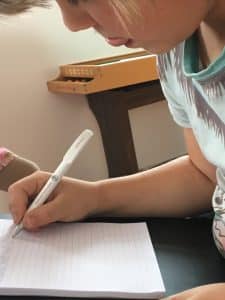 Een kind schrijft op een stuk papier.